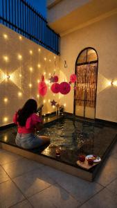 a woman sitting in front of a pool of water at The Benjamins Pool Villa in Jodhpur +7 photos
