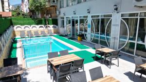 a swimming pool with tables and chairs next to a building at SUNMARİS CİTY HOTEl in Marmaris