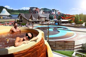 a woman laying in a swimming pool at a resort at Hotel Galeria Thermal Bešeňová in Bešeňová
