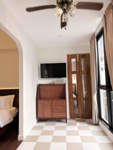 a bedroom with a ceiling fan and a television at Pennkiat House in Bangkok