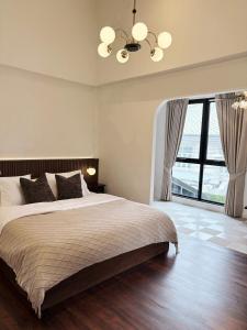 a bedroom with a large bed and a large window at Pennkiat House in Bangkok
