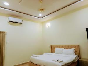 a bedroom with a bed and a air conditioner on the ceiling at Mega Grand Rooms in Narasaraopet +4 photos