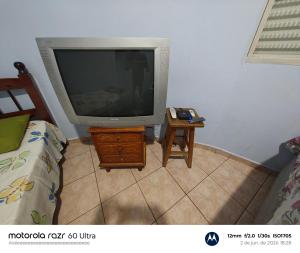 a tv sitting on a table next to a bed at Hotel Avenida Paraísopolis MG in Paraisópolis