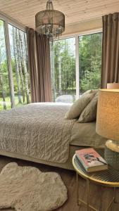 a bedroom with a large bed with a large window at For-rest Užsienis in Kazitiškis