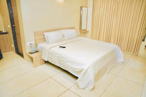 a bedroom with a large white bed in a room at Hotel Shri Ram Residency in Belgaum