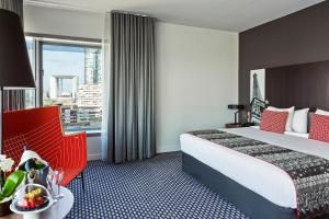 a hotel room with a bed and a large window at Meliá Paris La Défense in Courbevoie