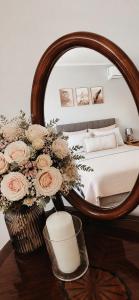 a bedroom with a bed with a mirror and flowers at Apartman Ivano in Vukovar +9 photos
