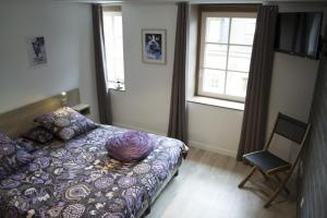 a bedroom with a bed and a chair and a window at Appartement12.com in Charleville-Mézières