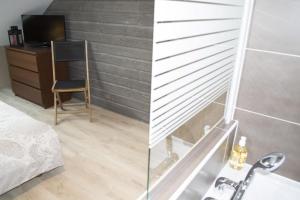 1 dormitorio con escritorio y baño con lavabo. en Appartement12.com en Charleville-Mézières