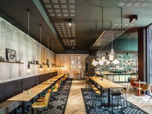 a restaurant with wooden tables and chairs and a bar at ibis Le Mans Centre Gare Nord in Le Mans