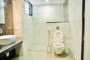 a bathroom with a toilet and a sink at Hotel Shri Ram Residency in Belgaum