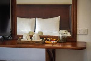 a table with a mirror and a tray with mugs at Namkhan Riverside Hotel in Luang Prabang