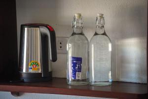two glass bottles sitting on a shelf next to a juicer at Namkhan Riverside Hotel in Luang Prabang