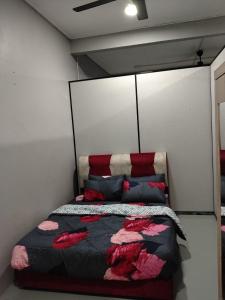 a bedroom with a bed with a black and red comforter at Roomstay Ust Omar in Tumpat
