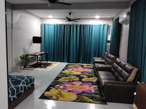 a living room with a couch and a rug at Roomstay Ust Omar in Tumpat