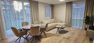 a living room with a couch and a table and chairs at Karaliauciaus Apartment in Vilnius +11 photos