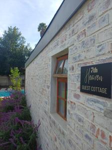 a brick building with a sign for a guest cottage at 7th Heaven Guest Cottage in Paarl