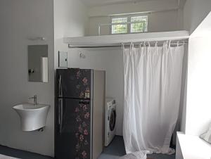 a bathroom with a sink and a black refrigerator at Casa De Campo in Idukki