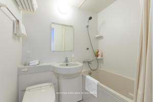 a white bathroom with a sink and a toilet at Always Niseko in Kutchan