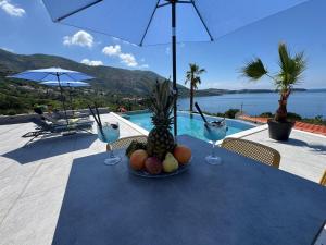 a bowl of fruit on a table next to a pool at Arba Seaview Residences Apartments in Mlini