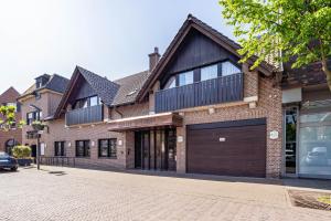 a brick house with a garage on a street at Hotel Deitmer in Rhede