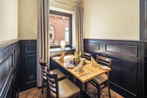 a dining room with a table and chairs and a window at Hotel Deitmer in Rhede