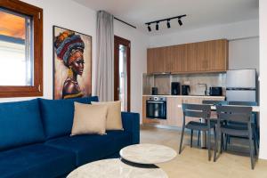 a living room with a blue couch and a kitchen at The Dandy Family Apartments in Syvota