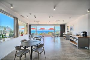 a living room with tables and chairs and a view of the ocean at STELLA'S BEACHFRONT - Aparthotel - FREE PARKING in Split