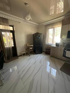 an empty room with a kitchen with a refrigerator at mado house in Chakvi