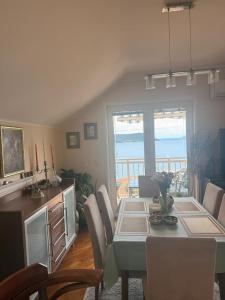 a dining room with a table and chairs and the ocean at Lovely duplex apartment in Savina