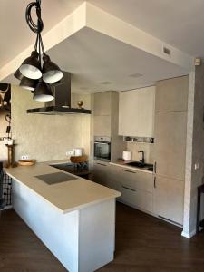 a kitchen with white cabinets and a island in it at Apartament Birutes 22 in Klaipėda