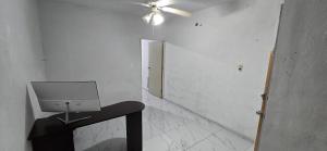 a white room with a ceiling fan and a chair at Departamentos De Cadereyta in Cadereyta Jiménez