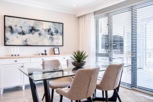 a dining room with a glass table and chairs at The Weinberg Windhoek in Windhoek +13 photos