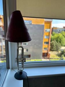 a lamp sitting on a window sill in front of a window at Apartament Birutes 22 in Klaipėda