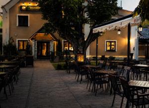 an empty patio with tables and chairs in front of a building at Hotel & Restaurant Pod Kaštany in Krupka