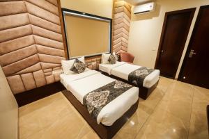 a hotel room with two beds and a mirror at HOTEL DHAROHAR in Pura Raghunāth