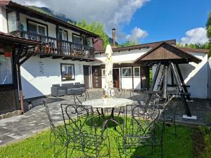 a table and chairs in front of a house at Casuța Râului in Zărneşti
