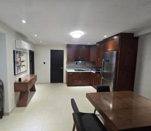 a kitchen with wooden cabinets and a table with chairs at Apartment with separate parking in Heroica Nogales +3 photos