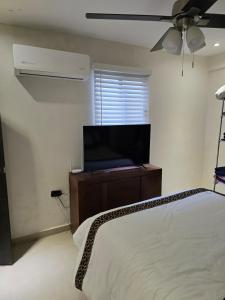 a bedroom with a bed and a flat screen tv at Apartment with separate parking in Heroica Nogales