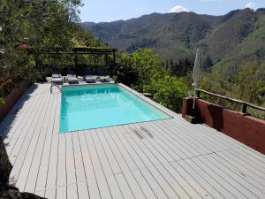 a swimming pool on a wooden deck with mountains in the background at Tuscan house, exclusive pool, private garden in Bagni di Lucca