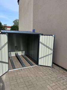 ein offenes Tor zu einem Gebäude neben einem Gebäude in der Unterkunft Apartment 45 - Moderne, ruhige 2 Zimmer-Wohnung mit WLAN in Wittenberge, Komplett ausgestattet mit EBK, ideal für Business, Privataufenthalte, Radfahrer sowie kurze und längere Aufenthalte - einzeln oder als Paar - Nahe Bahnhof, Zentrum - Fahrradgarage in Wittenberge