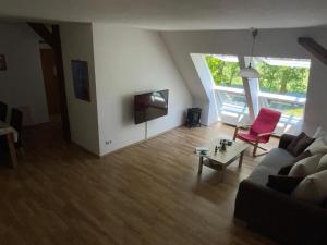 a living room with a couch and a tv at Wattenmeer-Ferien in Süllwarden