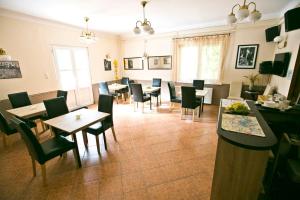 a restaurant with tables and chairs in a room at Boróka Panzió in Parád