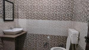 a bathroom with a white toilet and a sink at Sheetal Resort and Restaurant in Rudraprayāg +14 photos