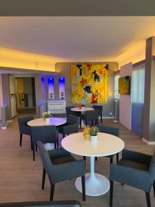 a waiting room with tables and chairs at Confidence Hotel Suzzara in Suzzara
