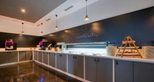 a restaurant kitchen with a counter with a counter top at PLAZA INN Salzburg Messe in Salzburg +32 photos