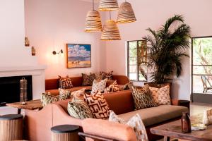 a living room with couches and a fireplace at Sedia Hotel in Maun