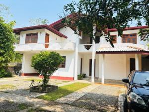 a house with a car parked in front of it at Peacock Forest Villa in Kosgoda