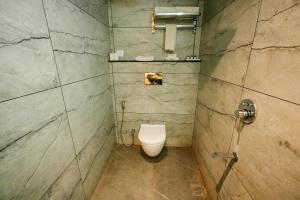 a bathroom with a toilet in a stone wall at HOTEL DHAROHAR in Pura Raghunāth +8 photos