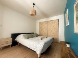 a bedroom with a bed in a room with blue walls at The globe trotter - Perpignan in Perpignan